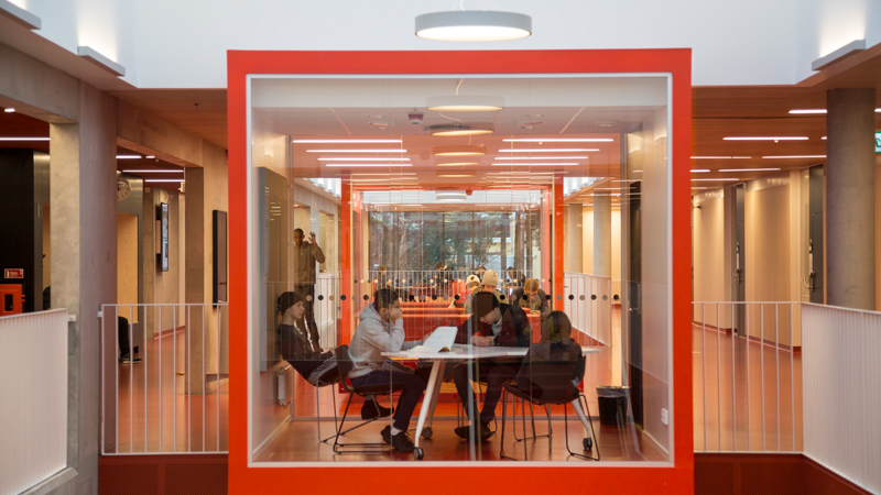 Elever syns genom en stor glasruta.